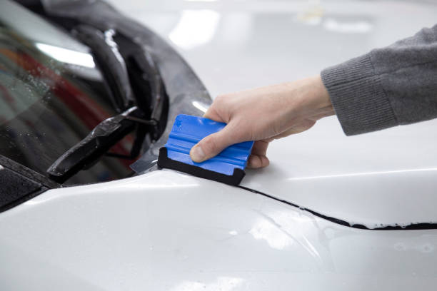 istock Installing a protective film on the car body 1197519601
