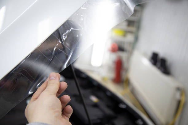 istock Installing a protective film on the car body 1197519616