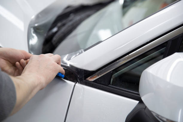 istock Installing a protective film on the car body 1197519618