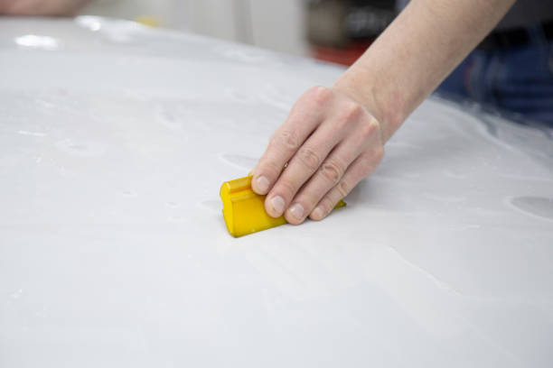 istock Installing a protective film on the car body 1197519625