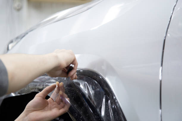 istock Installing a protective film on the car body 1197519682