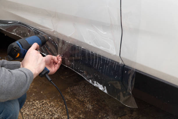 istock Installing a protective film on the car body 1197520283