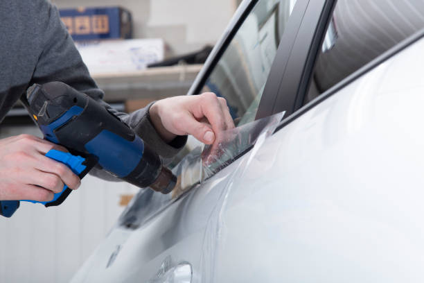 istock Installing a protective film on the car body 1197520285