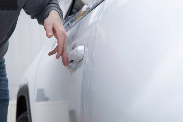 istock Installing a protective film on the car body 1197520286