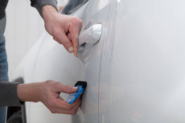 istock Installing a protective film on the car body 1197520289