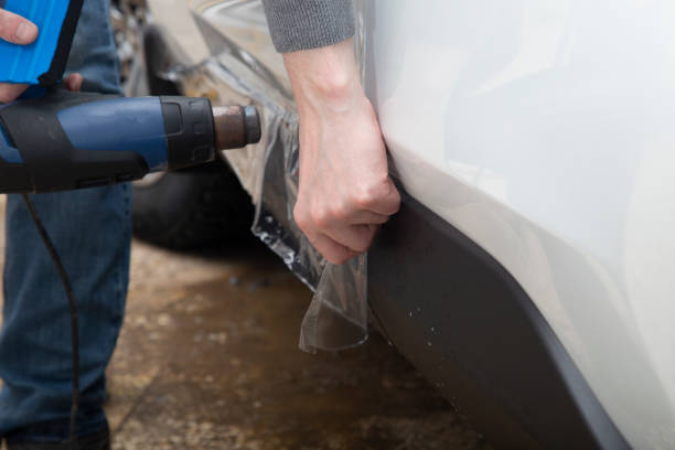 istock Installing a protective film on the car body 1197520294