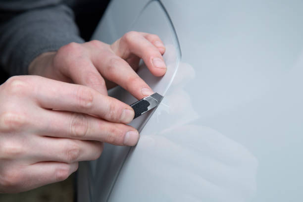 istock Installing a protective film on the car body 1197520307