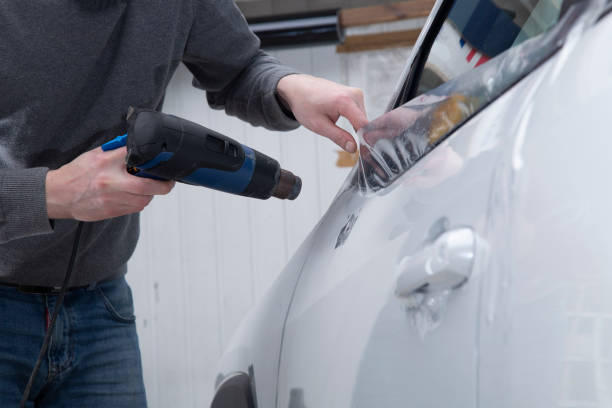 istock Installing a protective film on the car body 1197520313