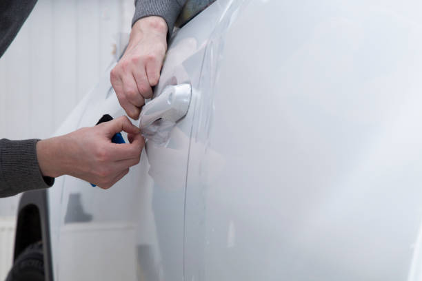 istock Installing a protective film on the car body 1197520316