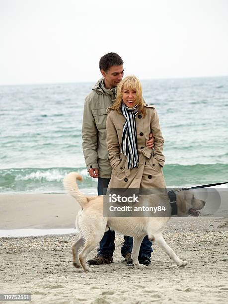 Mid Aged Couple With Dog On Sea Shore Stock Photo - Download Image Now - Beach, Couple - Relationship, Dog