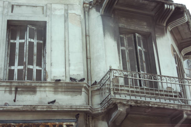 Exterior of apartment building with balcony and tall windows.