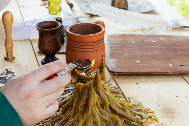 istock medieval background a man holds a spoon for rose heating wax over a handmade burning candle and clay pot 1197532630