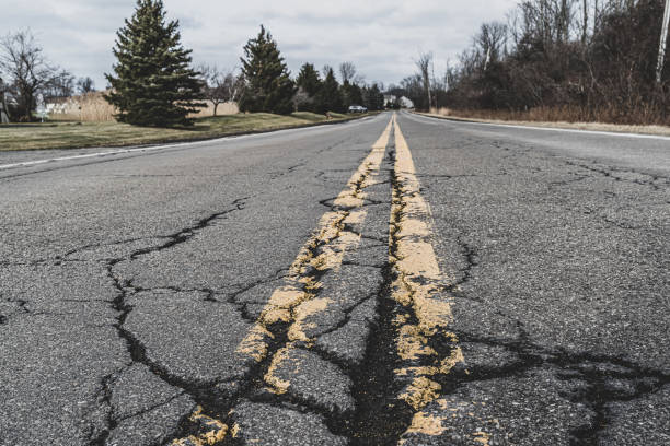 Close up of road markings and cracked asphalt of a suburban road stock photo
