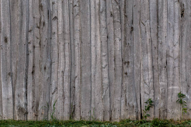 istock gray wooden weathered barn wall flat background template with green grass 1197533243