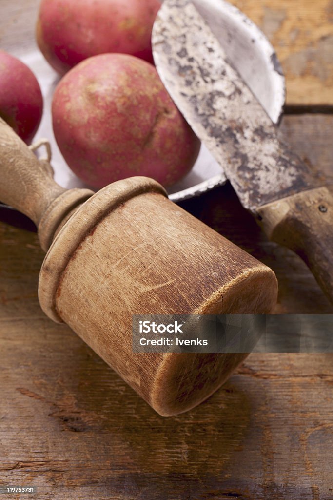 retro Kartoffelstampfer und Messer auf alten Holztisch - Lizenzfrei Alt Stock-Foto