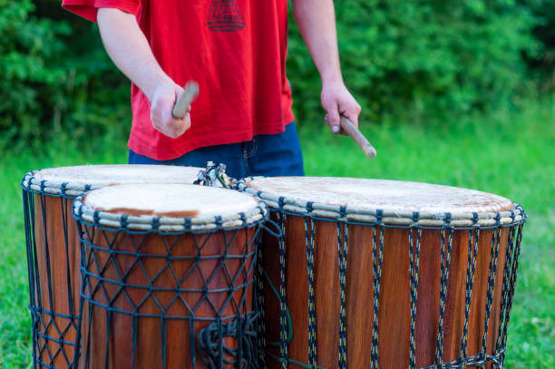 istock A man playing African and cylindrical dundun drums with kala sticks 1197537754