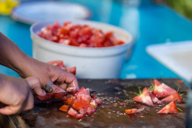 istock hands cutting a lot of red tomatoes 1197538387