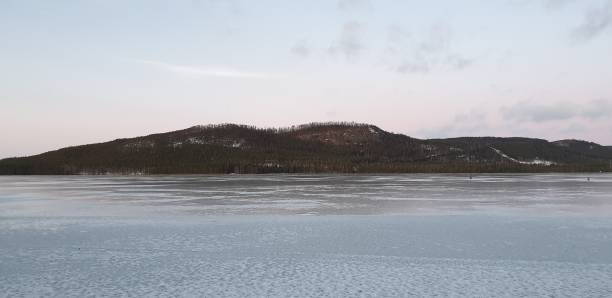 istock Ice on the lake at sunset with a mountain as background 1197541137