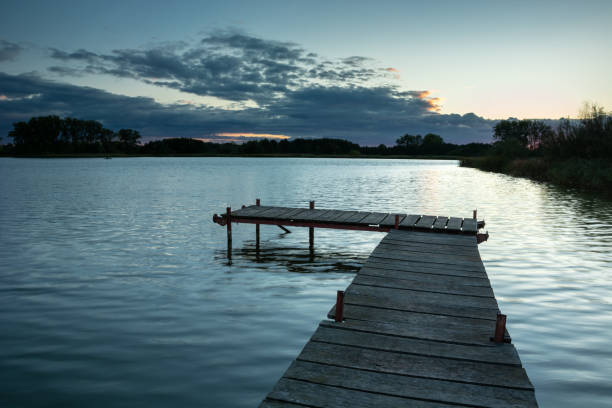 istock Jetty on a calm lake and clouds, evening view 1197542250