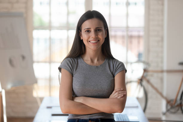 istock Female worker with arms crossed looking at camera pose indoors 1197547369
