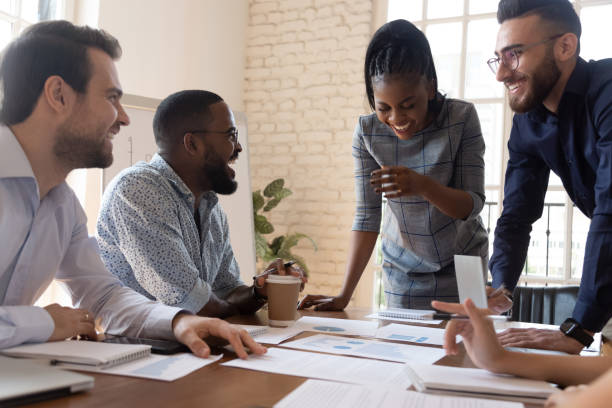 istock Multi racial employees joking and laughing during briefing in boardroom 1197547385