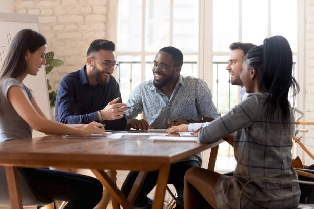istock Diverse employees sitting at table having pleasant positive conversation 1197547407