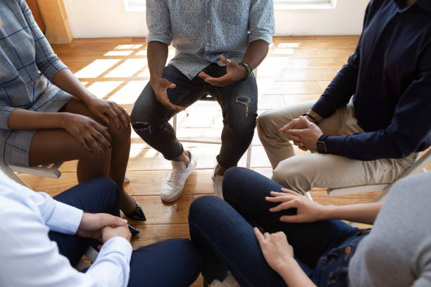 diverse people during psychological rehab session sitting indoors - grupo pequeno de pessoas imagens e fotografias de stock