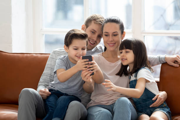 istock Excited family hugging, entertaining, using mobile phone. 1197547461