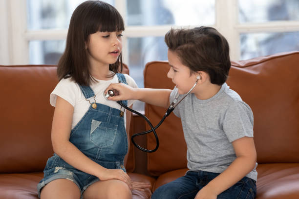 istock Two siblings playing hospital game at home. 1197547519