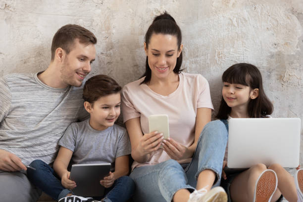 happy addicted to technology family using different gadgets. - laptop women child digital tablet imagens e fotografias de stock
