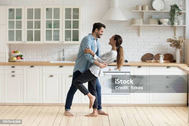 Feliz Pareja Romántica Bailando En La Cocina Moderna En Casa Foto de stock y más banco de imágenes de Parejas