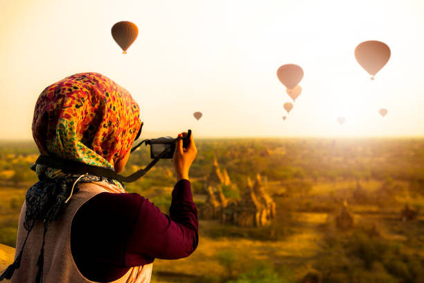 an asian woman taking picture with her camera in Bagan, Myanmar
