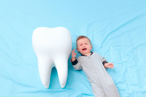 istock Crying Baby Girl Having Her First Milk Tooth 1197556726