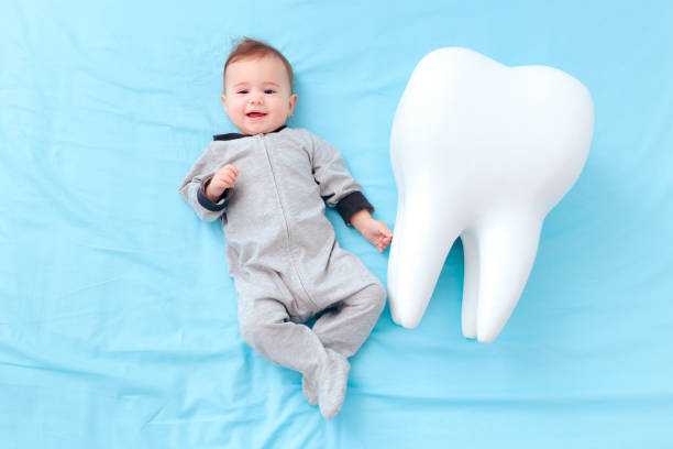 Happy Baby Girl Having Her First Milk Tooth Newborn going trough teething at six months milestone baby teeth stock pictures, royalty-free photos & images