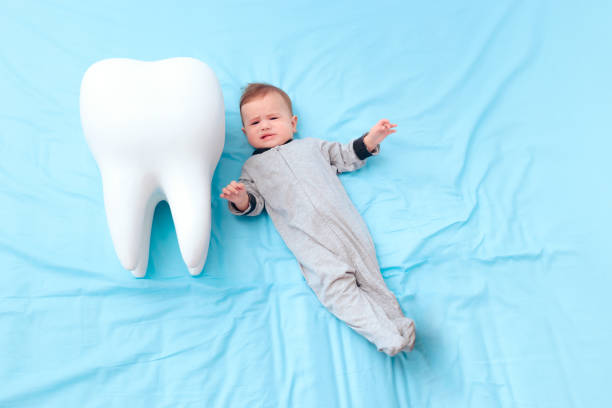 istock Crying Baby Girl Having Her First Milk Tooth 1197556744