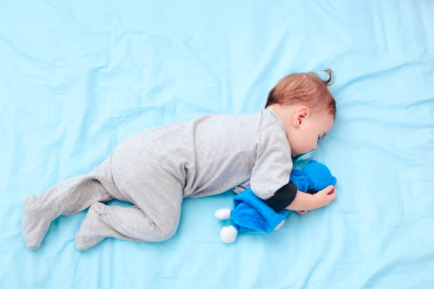 istock Cute Baby Sleeping with Pacifier and Favorite Toy 1197556871