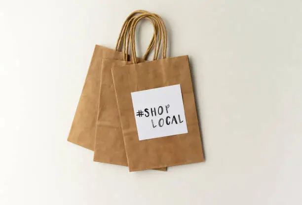 Photo of #ShopLocal stamped on a paper bag - shop local message for small retailers / businesses