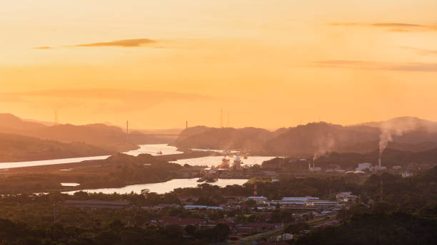 container ships passing through panama canal in scenic landscape at sunset - panama canal panama mountain sunset imagens e fotografias de stock