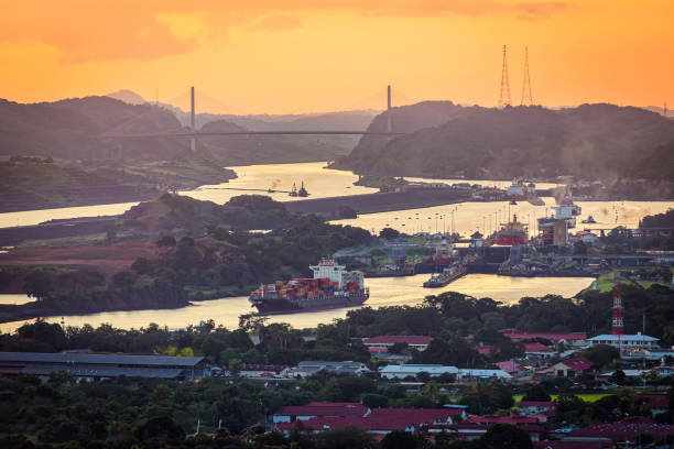 container ships passing through panama canal in scenic landscape at sunset - panama canal panama mountain sunset imagens e fotografias de stock