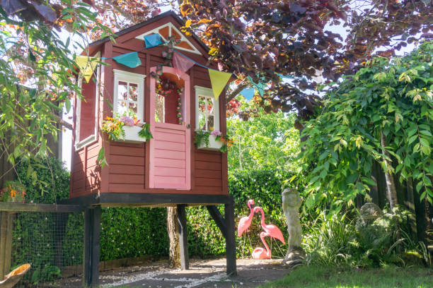 Children's play house on leafy area of garden Children's play house on stilts in leafy area of garden playhouse stock pictures, royalty-free photos & images