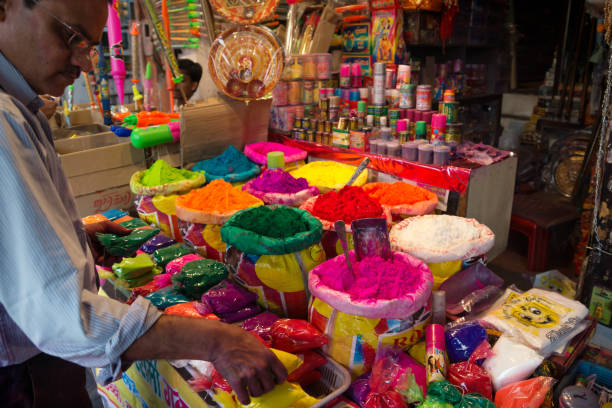 Indian Salesman in front of his shop selling colorful powder for Holi Festival, Jaipur, Rajasthan, India Indian Salesman in front of his shop selling colorful powder in bags for Holi Festival, Jaipur, Rajasthan, India india jaipur rajasthan traditional culture stock pictures, royalty-free photos & images