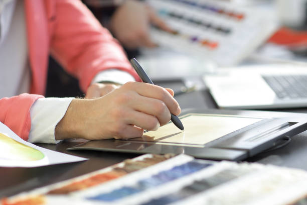 istock close up. a graphic designer uses a graphics tablet sitting at Desk in Studio 1197567890