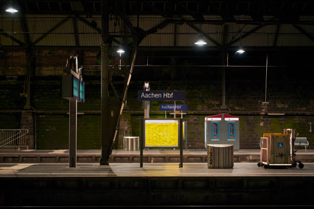 Aachen, Germany - November 3, 2019: View of an empty, clean platform at Aachen Main Train Station during night time with artificial lighting