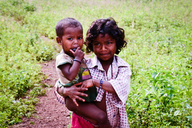 elder sister carrying younger brother, rural India, at Rajahmundry, Andhra pradesh, INDIA