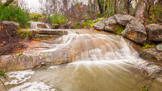 A fast running stream with small waterfalls in a woodland soth of Sydney, Australia.