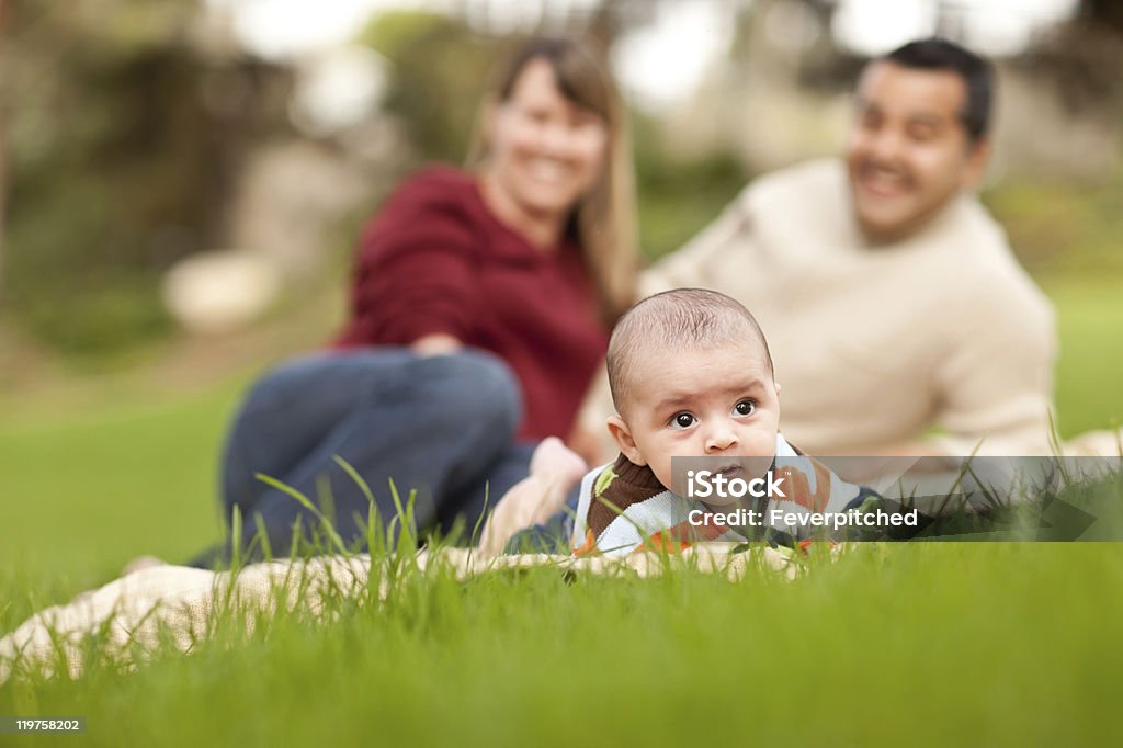 Feliz menino bebê e mix de corrida pais brincando no parque - Foto de stock de Família royalty-free