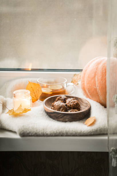 istock autumn still life: pumpkin and cookies on the windowsillac 1197584365