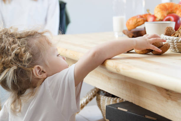 istock Little child in white t-shirt eats cookies before breakfast. 1197588963