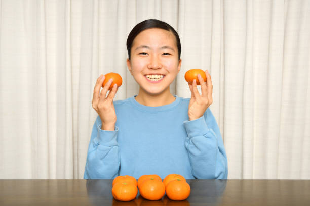 istock Japanese girl enjoys having mandarin orange 1197589621