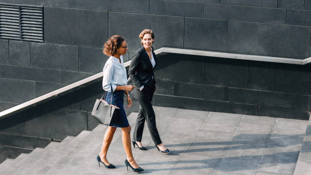 istock Two women in office wear walking outdoors and talking 1197591798